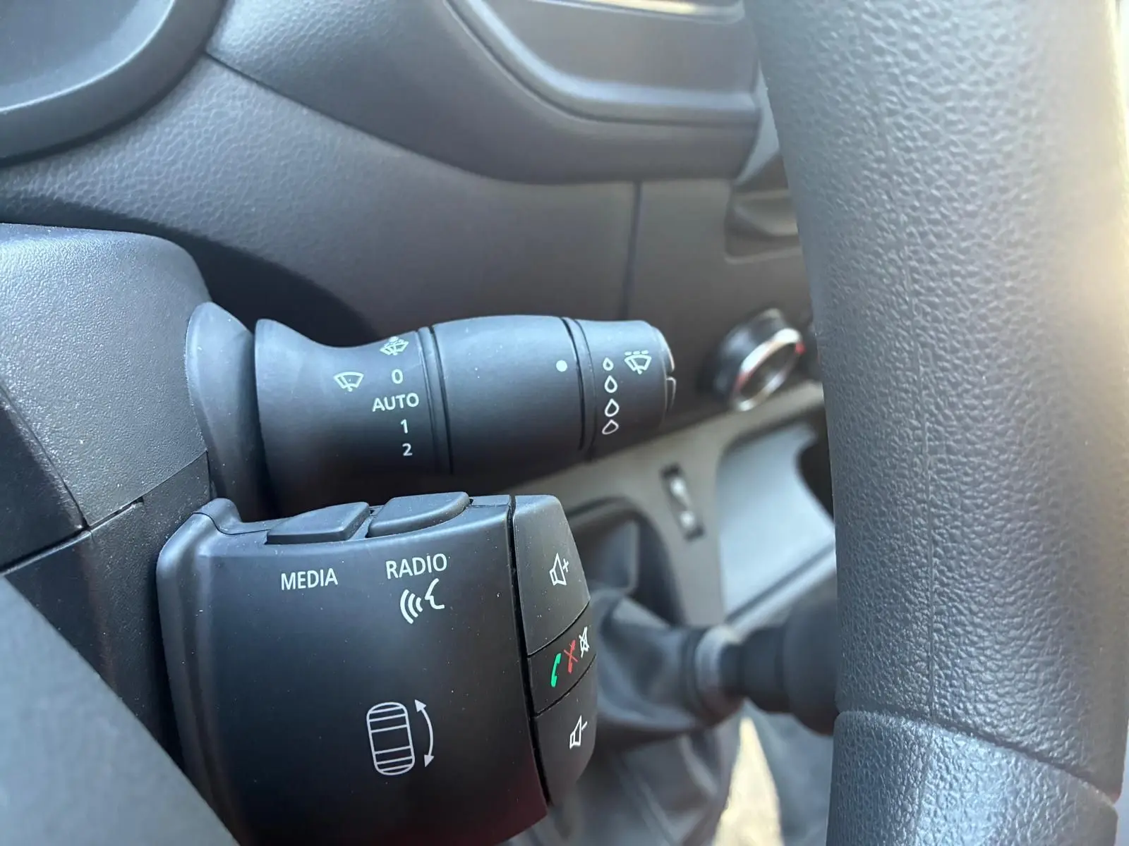 Gros plan sur la commande au volant du Renault Master 2023 gris, avec boutons média, radio et commandes d’essuie-glace.