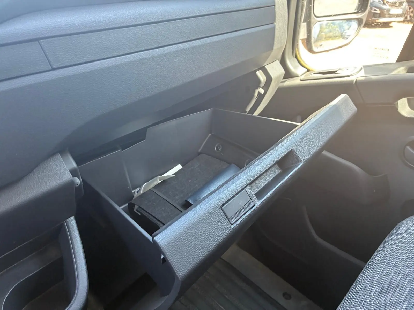 Vue intérieure côté passager du Renault Master 2023, boîte à gants ouverte avec rangement noir visible.