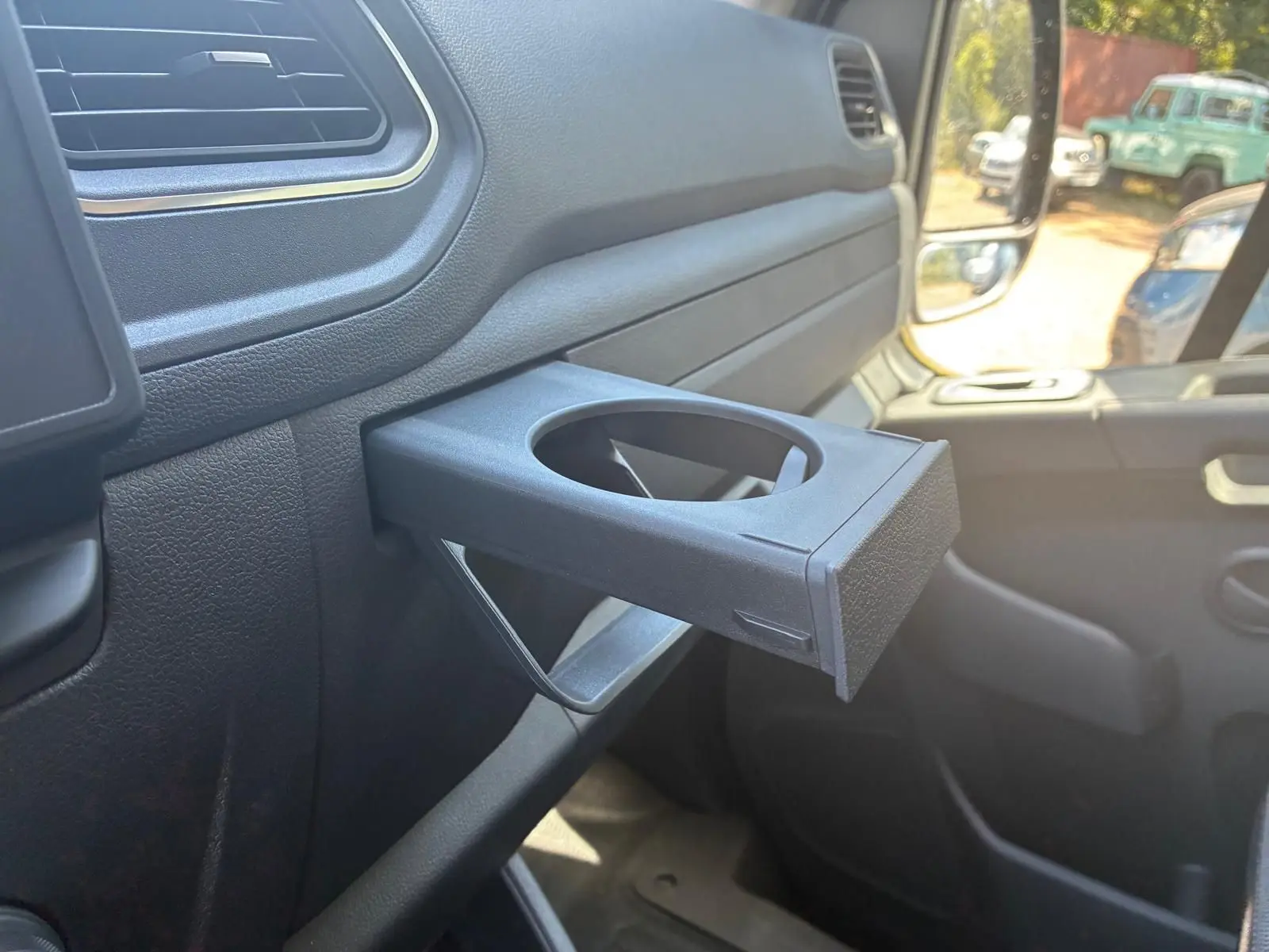 Détail intérieur du porte-gobelet déployé côté passager du Renault Master gris 2023, vue rapprochée.
