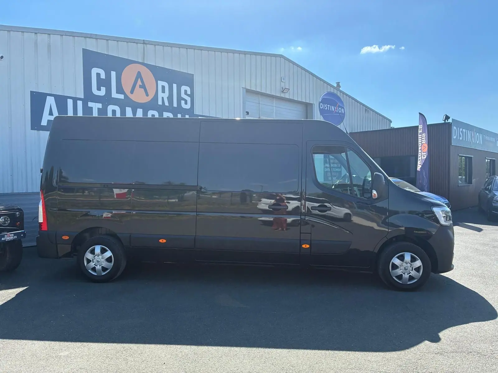 Vue de profil côté droit d’un Renault Master gris 2023, fourgon long avec jantes acier et vitres teintées.