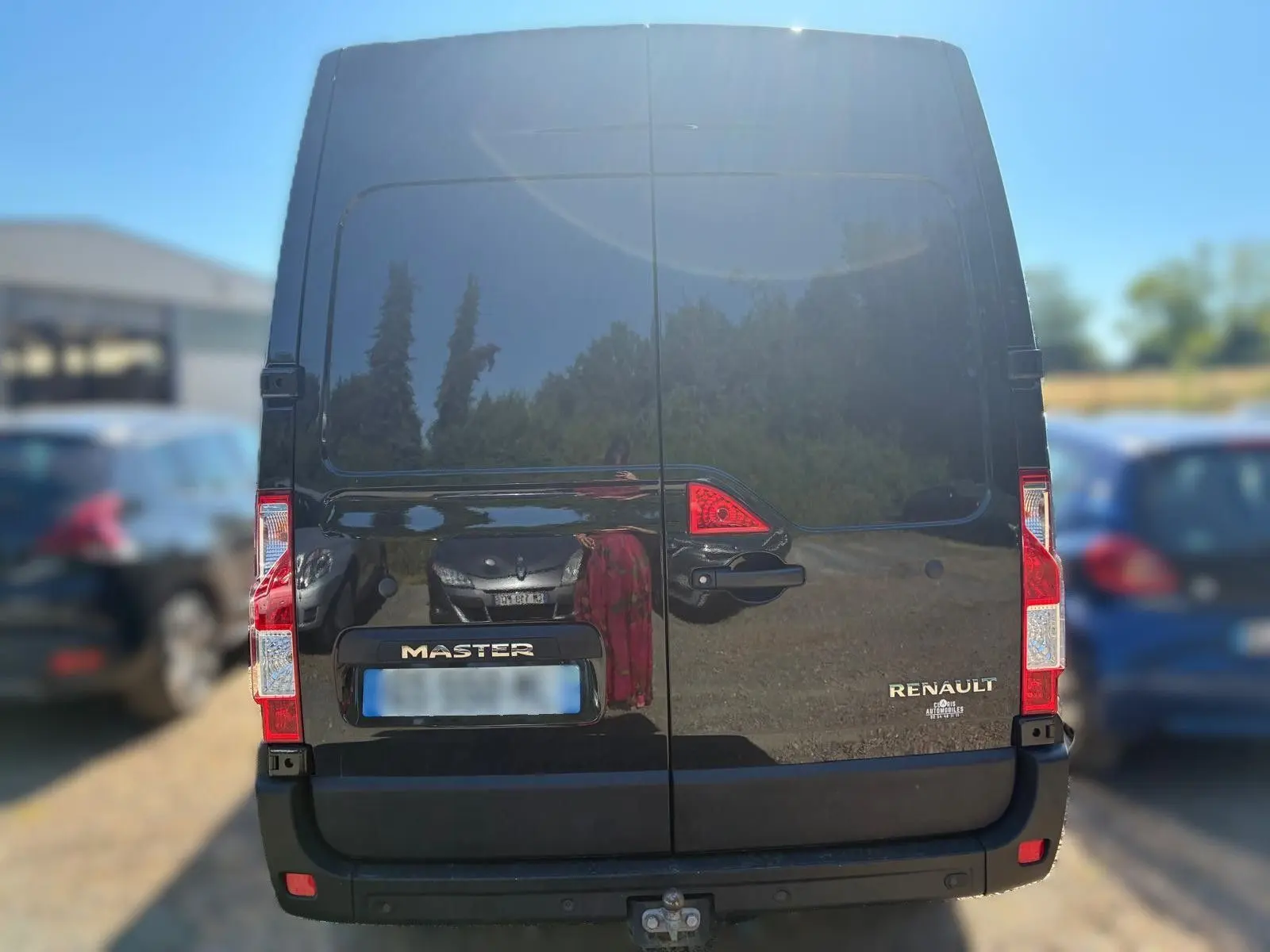 Vue arrière d’un Renault Master gris 2023 avec portes battantes et attelage visible en bas.