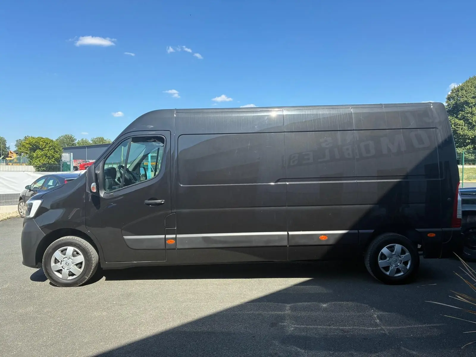 Vue latérale droite d’un Renault Master gris 2023 version Grand Confort, fourgon utilitaire long avec toit haut.