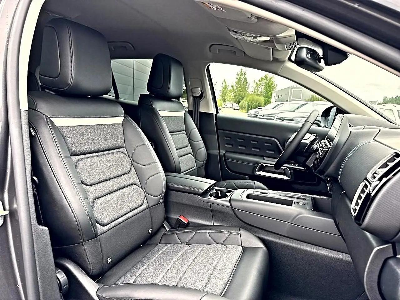 Vue intérieure côté conducteur du Citroën C5 Aircross 2025 gris platinium, sièges cuir et tissu, console centrale moderne.