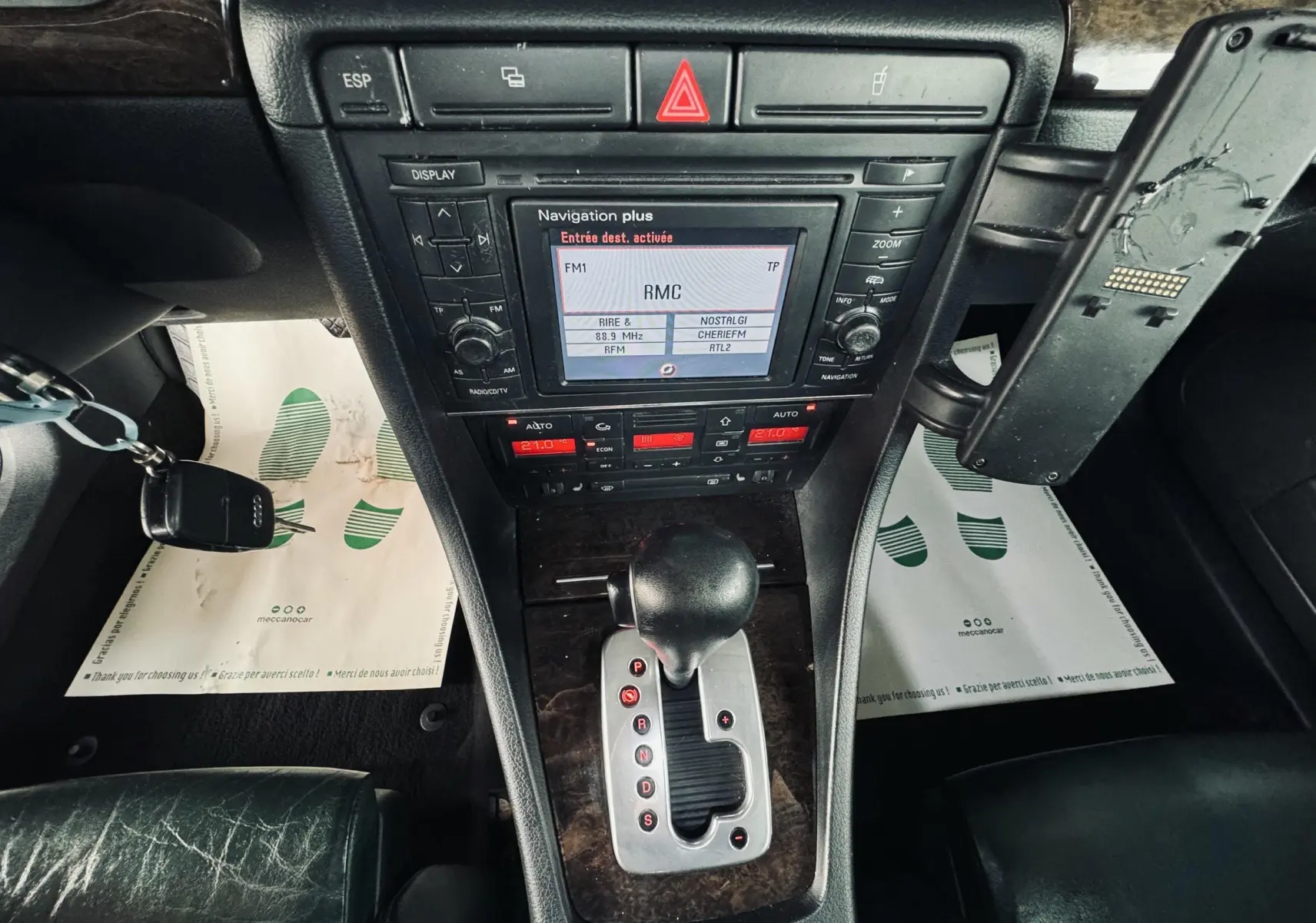 Vue plongeante sur la console centrale noire de l'Audi S4 Avant 2004 avec levier de vitesses automatique et écran de navigation.