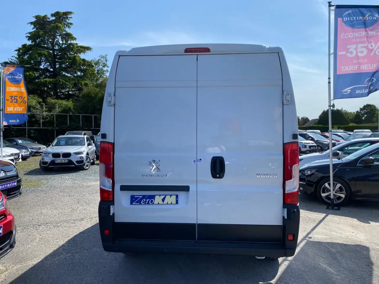 Vue arrière d'un Peugeot Boxer Fourgon blanc 2023 avec portes battantes et logo visible sur un parking.