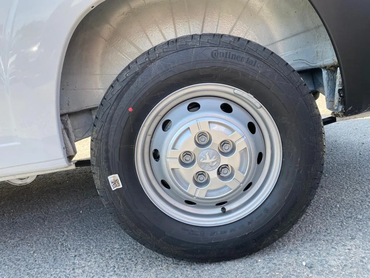 Gros plan sur la roue avant gauche blanche d'un Peugeot Boxer Fourgon 2023 avec jante acier et pneu Continental.