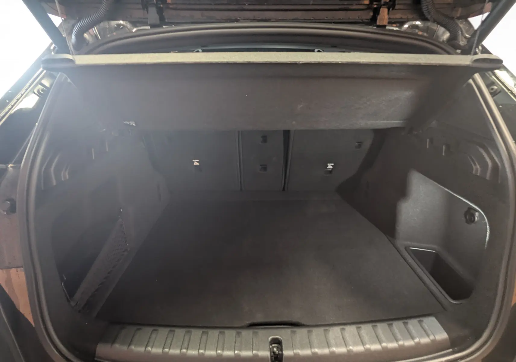 Vue arrière du coffre ouvert noir du BMW X1 U11 sDrive 18d 2025, montrant un espace de chargement spacieux et propre.