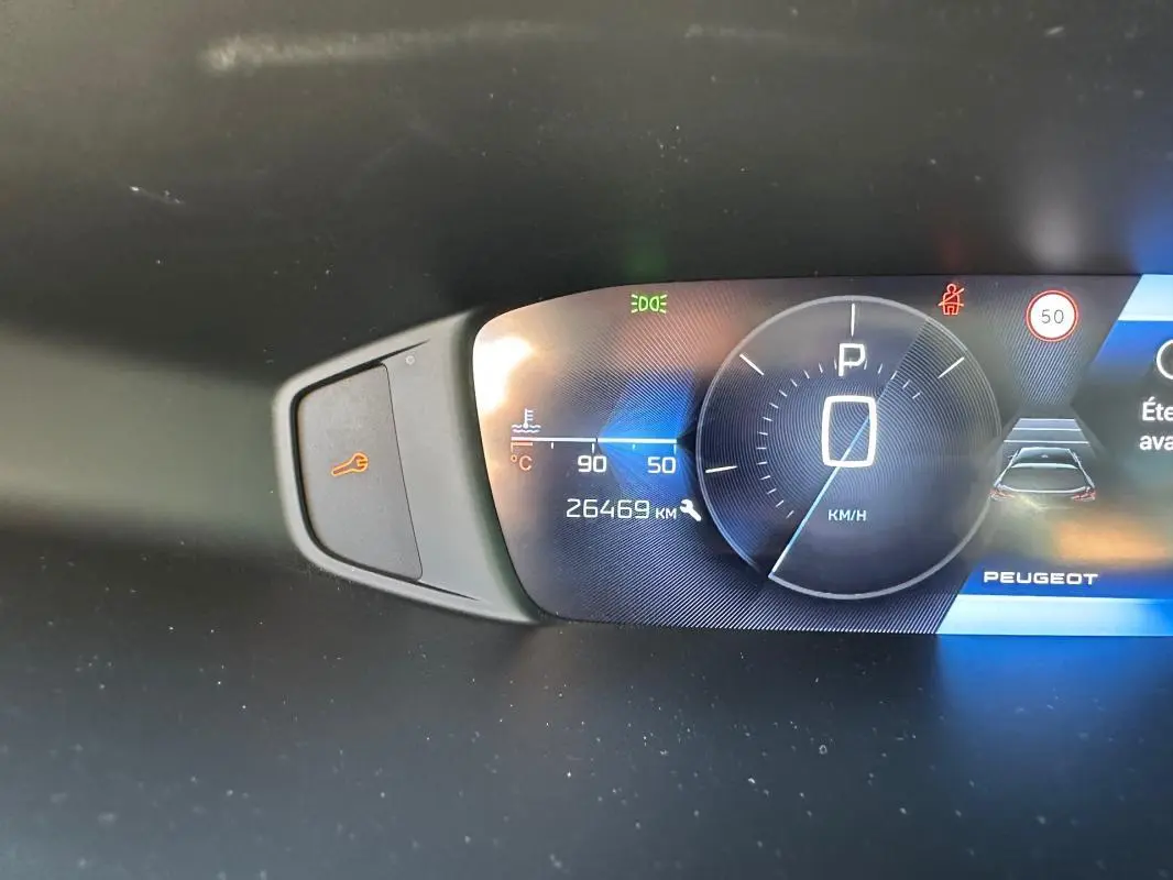 Tableau de bord numérique de Peugeot 308 SW Hybrid noir, affichant vitesse à 0 km/h et 26 469 km au compteur.