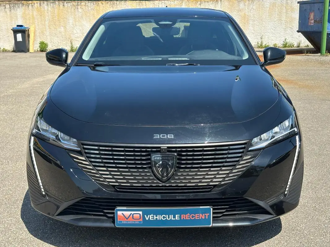 Vue frontale d'une Peugeot 308 SW Hybrid 145 noire, mettant en valeur sa calandre moderne et ses phares LED fins.