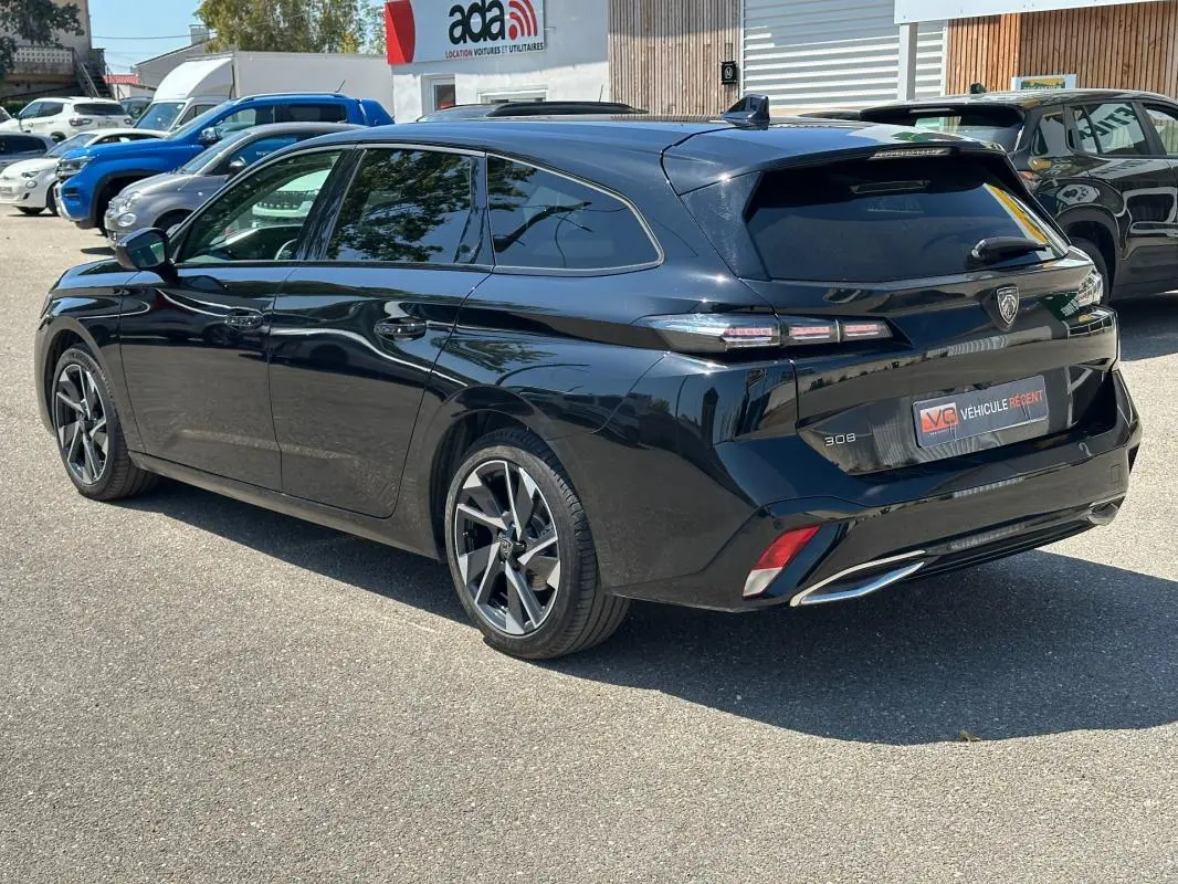 Peugeot 308 SW Hybrid noir vue 3/4 arrière droit, avec jantes alliage 17 pouces et feux arrière LED distinctifs.