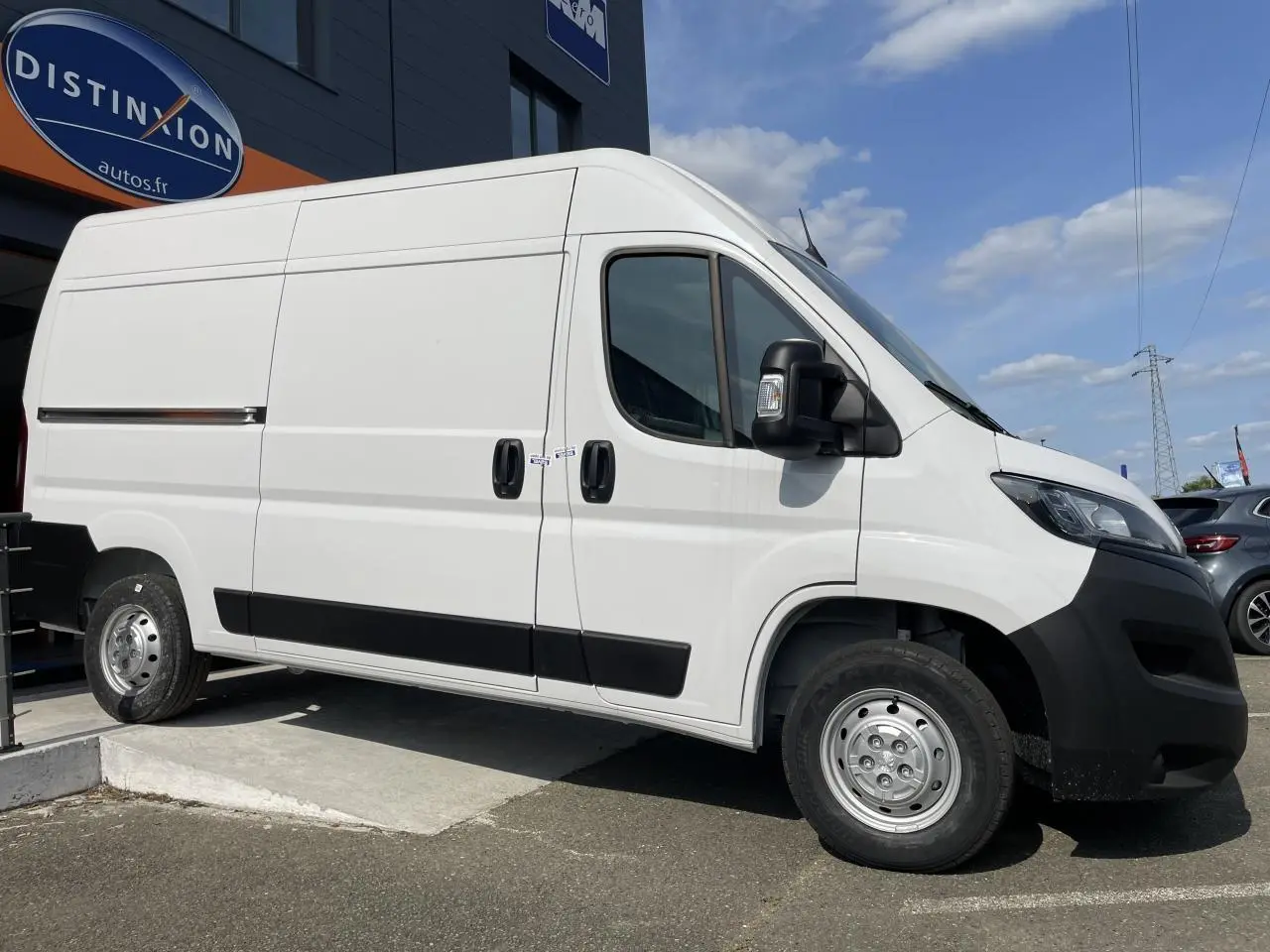 Peugeot Boxer Fourgon blanc vu de profil côté droit, avec porte latérale coulissante et jantes acier simples.
