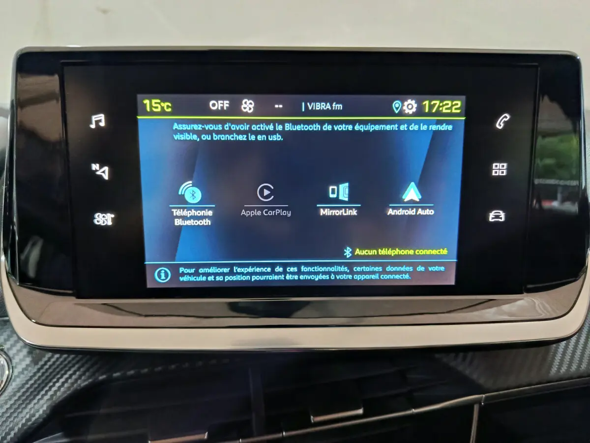 Écran tactile central allumé de la Peugeot 208 électrique 2023, affichant les options Bluetooth et Apple CarPlay.