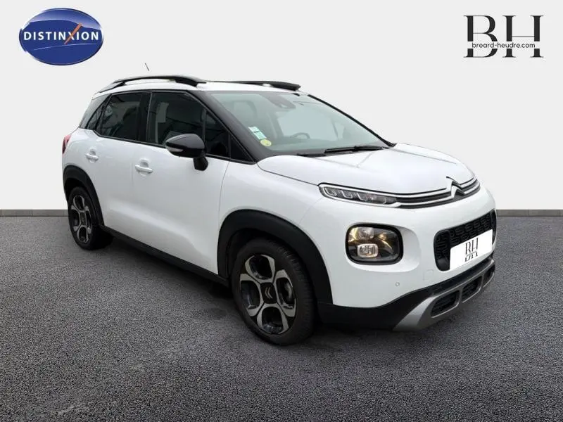 Citroën C3 Aircross blanc Natural White en 3/4 avant droit avec barres de toit et jantes diamantées noires.
