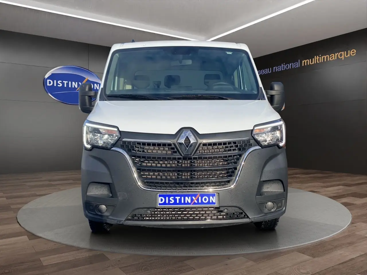 Vue frontale d’un Renault Master blanc 2024 avec calandre noire et logo Renault bien visible, en showroom.