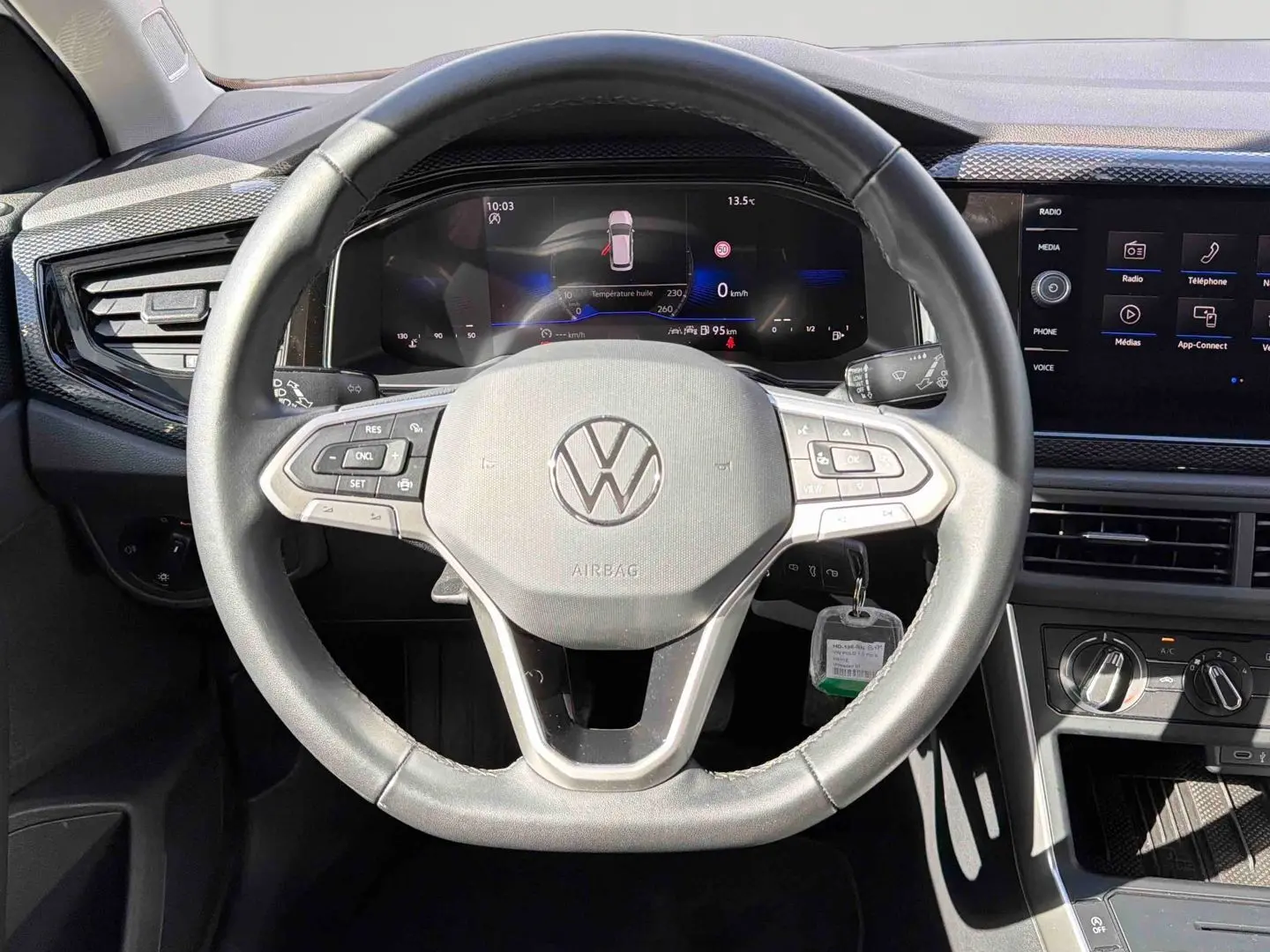 Vue frontale du volant cuir noir et du tableau de bord digital de la Volkswagen Polo 2025 avec écran tactile et commandes intégrées.