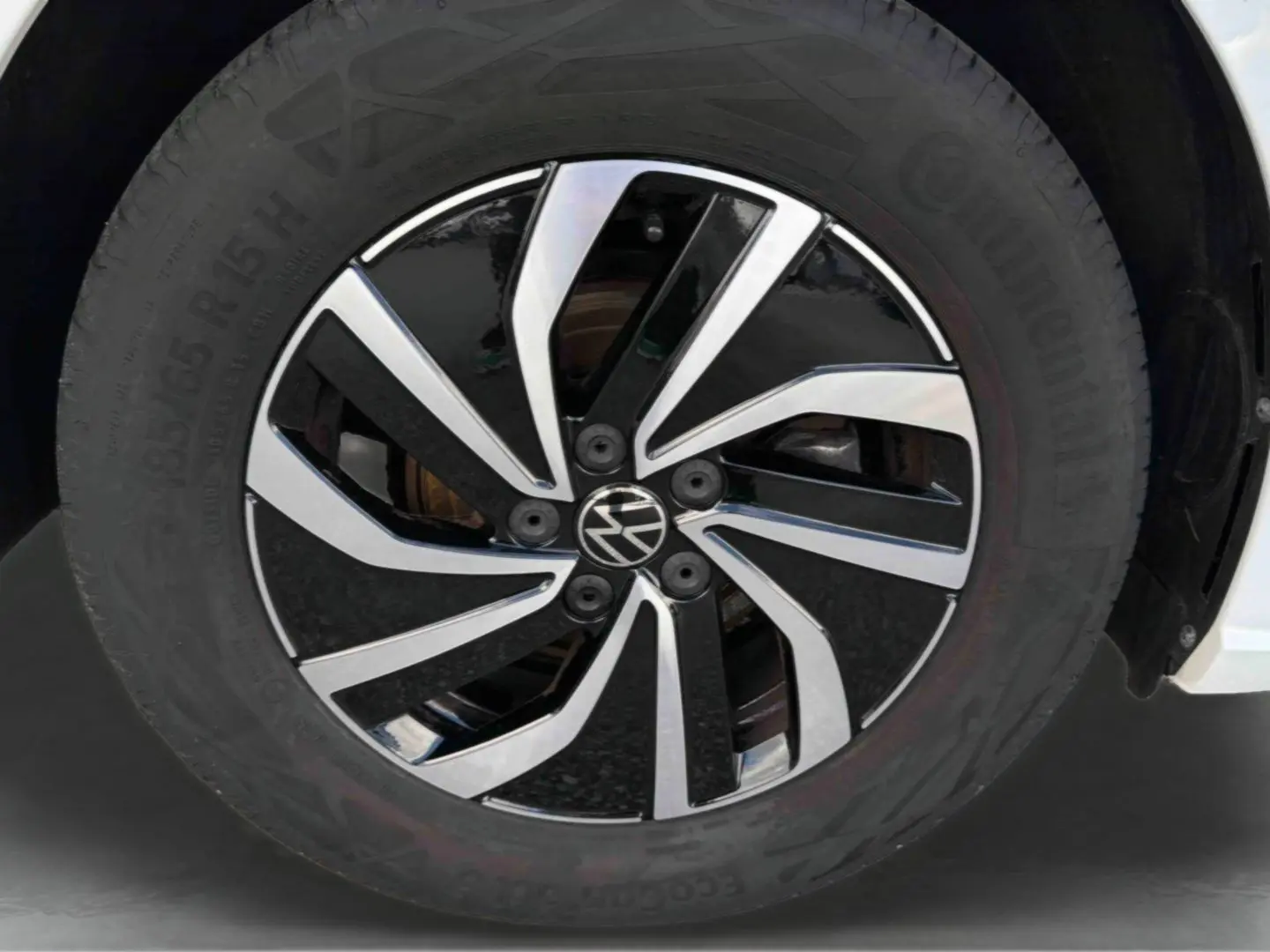 Gros plan sur la jante alliage noir et argent de 15 pouces d'une Volkswagen Polo blanche, avec pneu Continental visible.