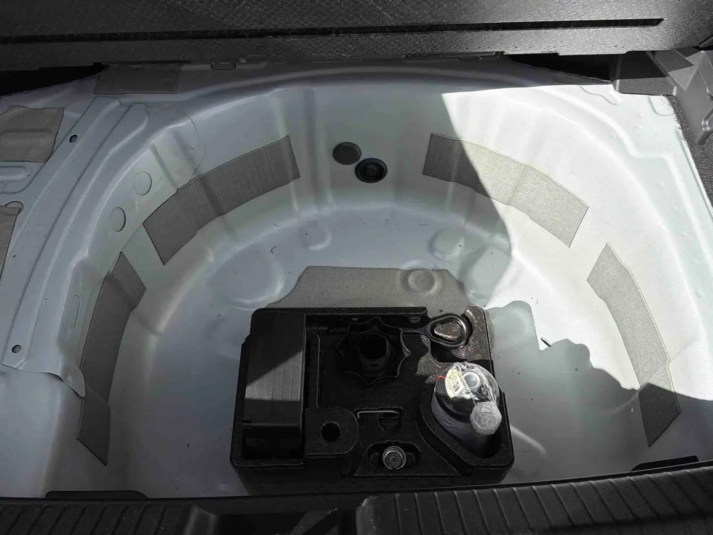 Coffre ouvert montrant la roue de secours blanche et un kit d’outils noir au centre du Volkswagen Polo 2025.