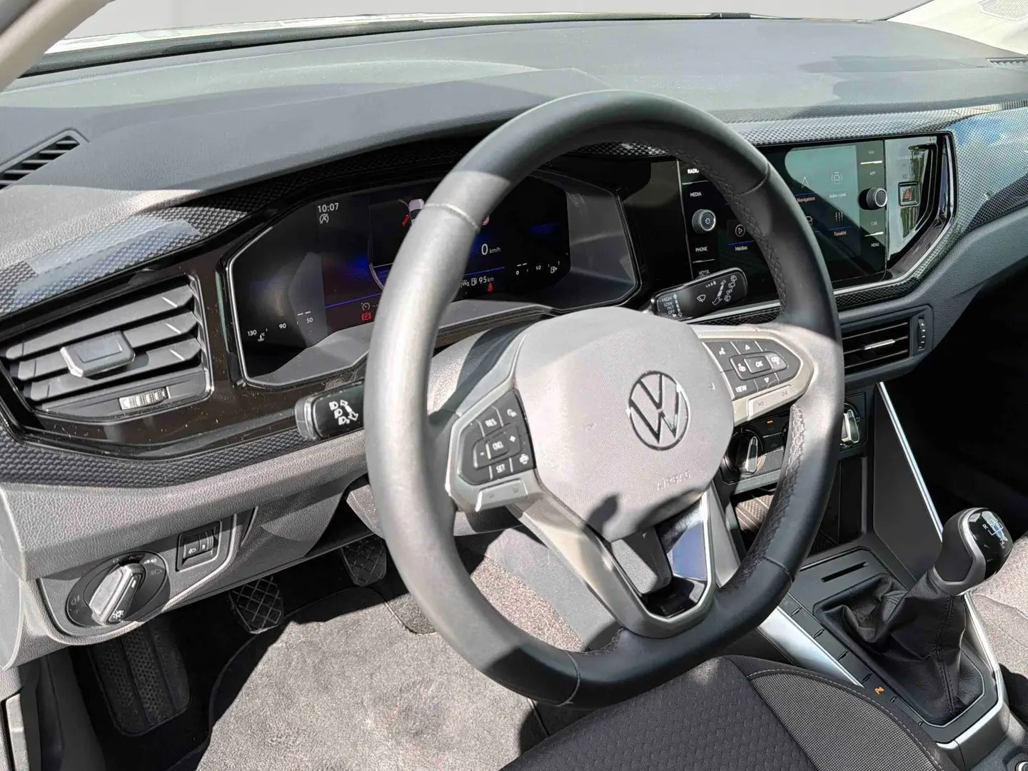 Vue intérieure côté conducteur du volant cuir et tableau de bord digital de la Volkswagen Polo 2025 avec boîte manuelle.