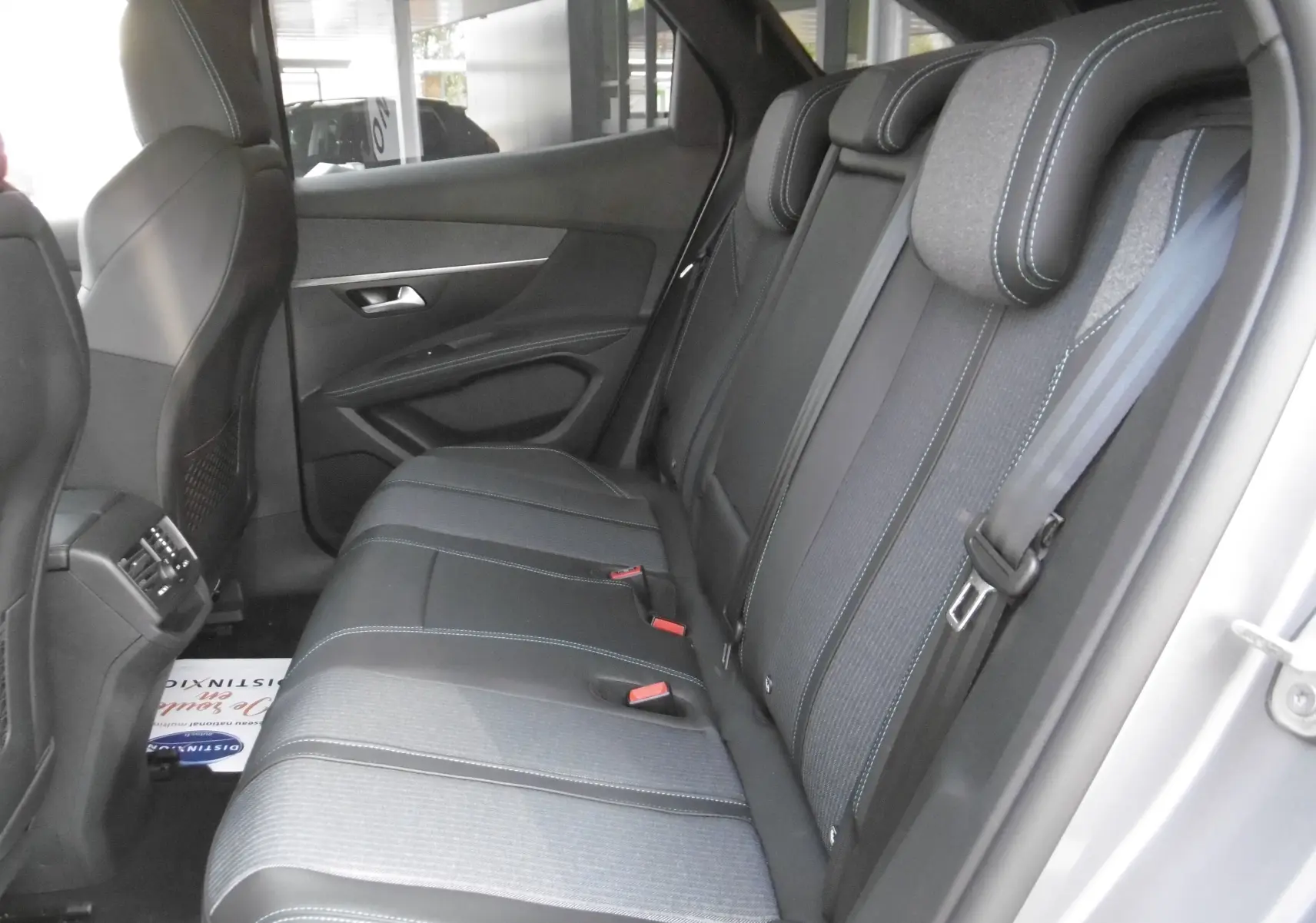 Vue intérieure côté droit des sièges arrière en cuir noir et tissu gris du Peugeot 3008 Hybrid 225ch finition Allure Pack 2021.