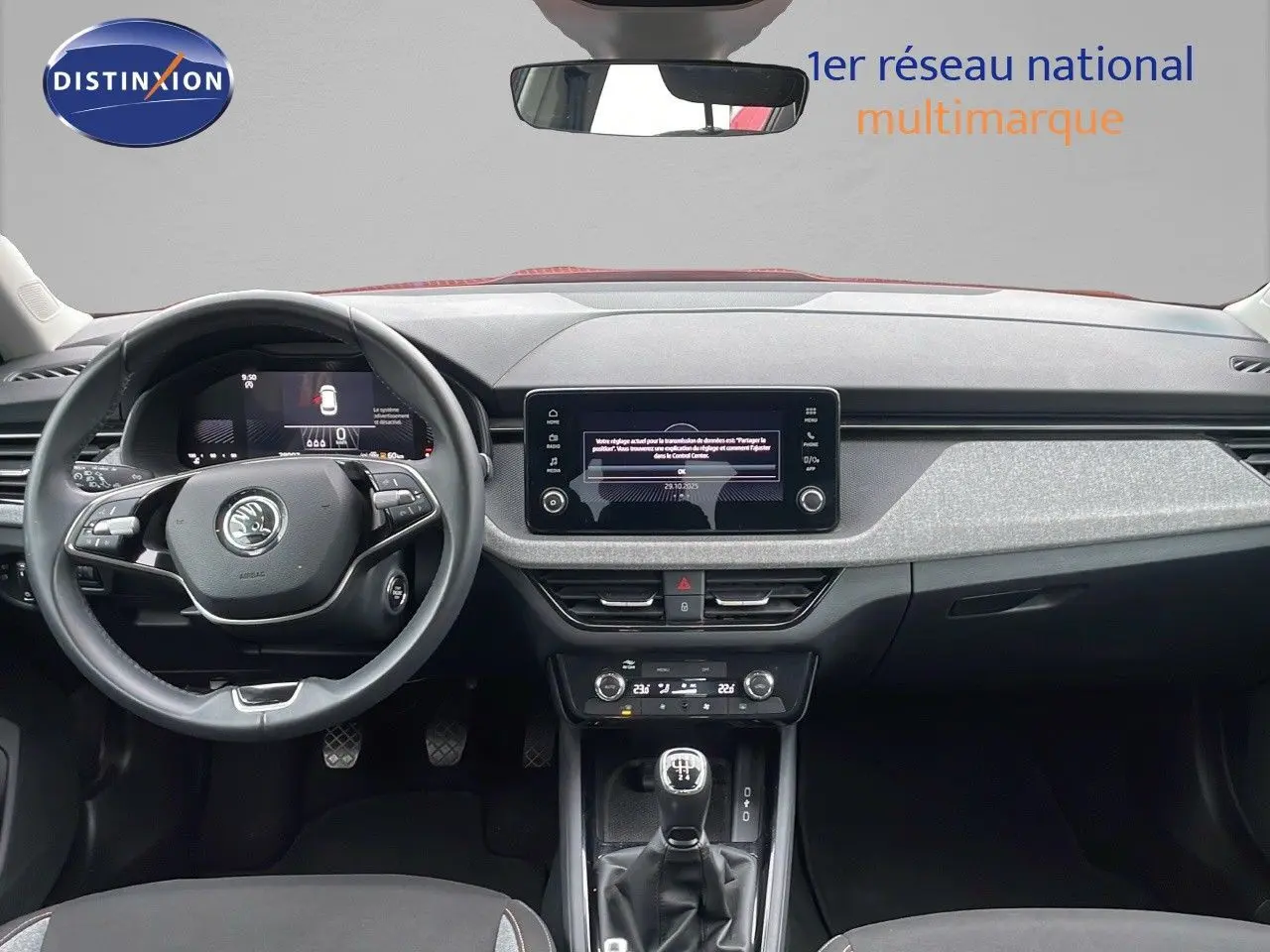 Vue frontale de l'habitacle du Skoda Kamiq rouge velvet metal 2024, avec tableau de bord moderne et boîte manuelle.