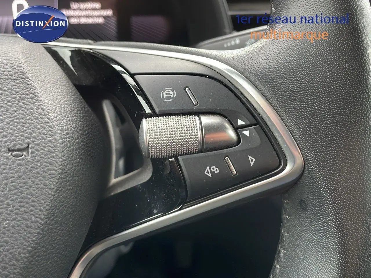 Gros plan sur les commandes multifonctions à droite du volant en cuir du Skoda Kamiq 2024 rouge Velvet Metal.