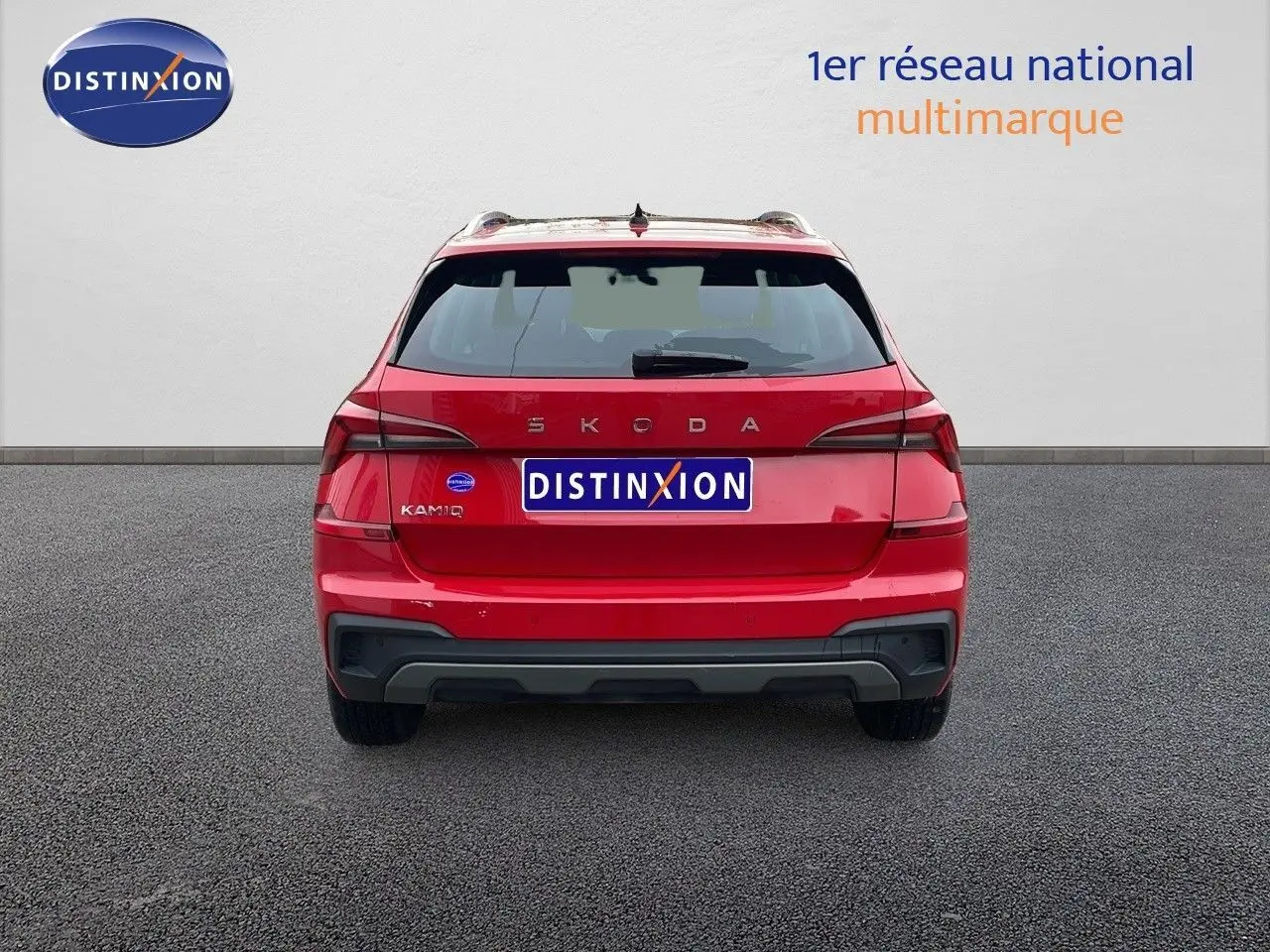 Vue arrière d'un Skoda Kamiq rouge Velvet Metal 2024 avec feux LED et hayon fermé sur sol gris.