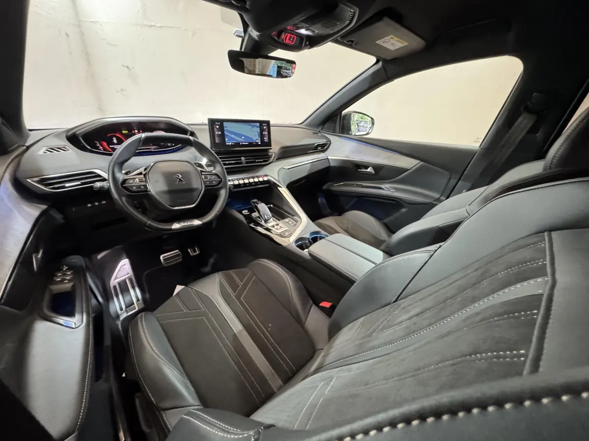 Vue intérieure côté conducteur du Peugeot 3008 GT 2021, sièges cuir noirs et tableau de bord digital avec écran tactile central.