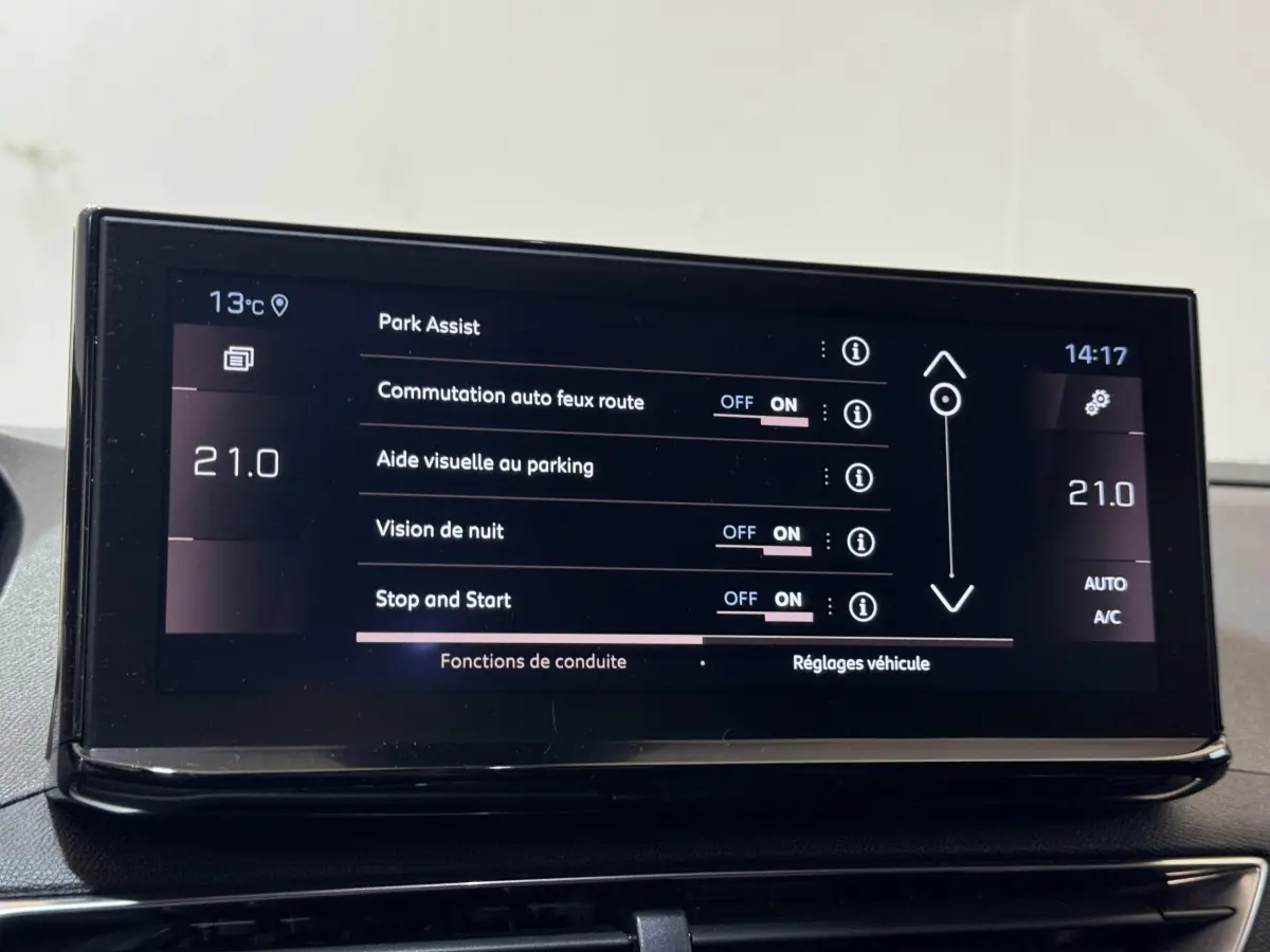 Écran tactile central du Peugeot 3008 GT 2021 affichant les réglages d’aide au stationnement et climatisation à 21°C.