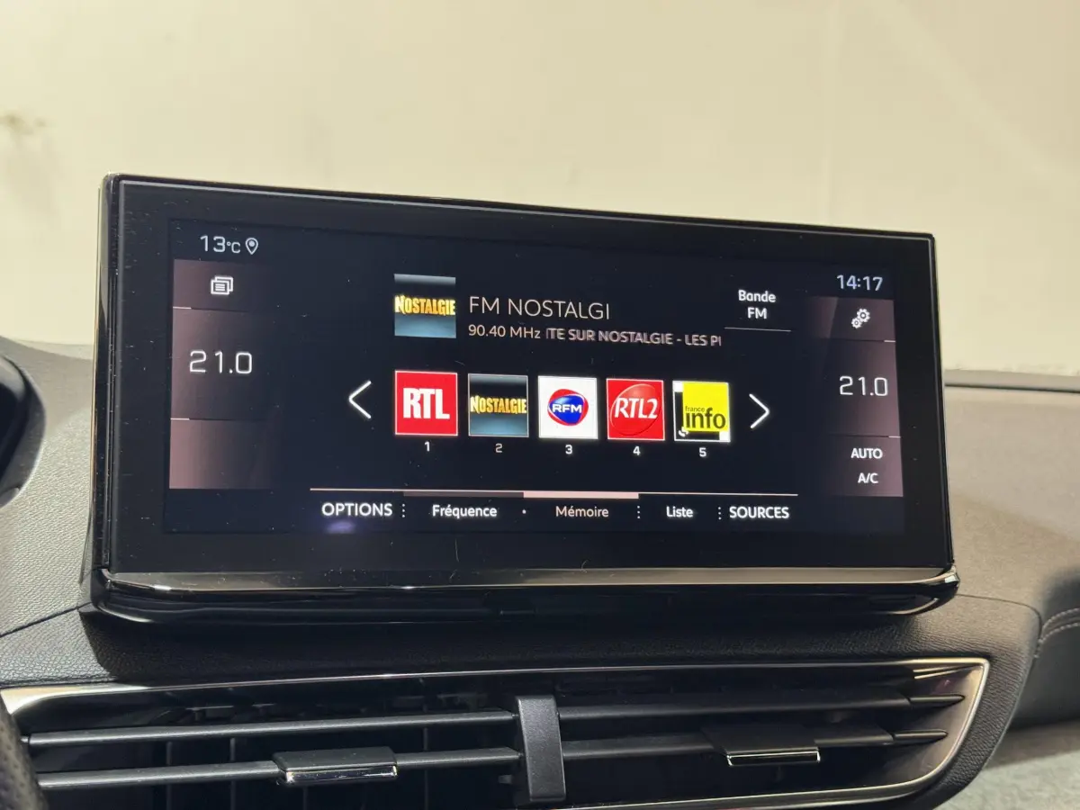 Écran tactile central de la Peugeot 3008 GT 2021 affichant les stations radio, vue intérieure du tableau de bord.
