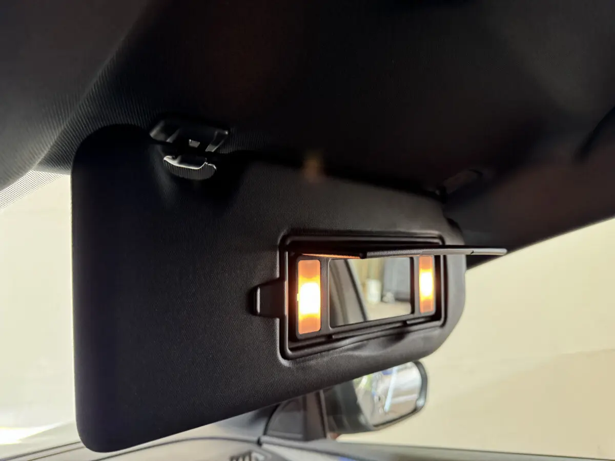 Détail du pare-soleil côté conducteur avec miroir éclairé dans l'habitacle d'un Peugeot 3008 gris clair 2021.