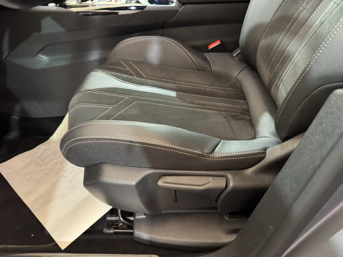 Gros plan sur le siège avant droit en cuir noir et alcantara avec surpiqûres blanches du Peugeot 3008 GT gris clair.