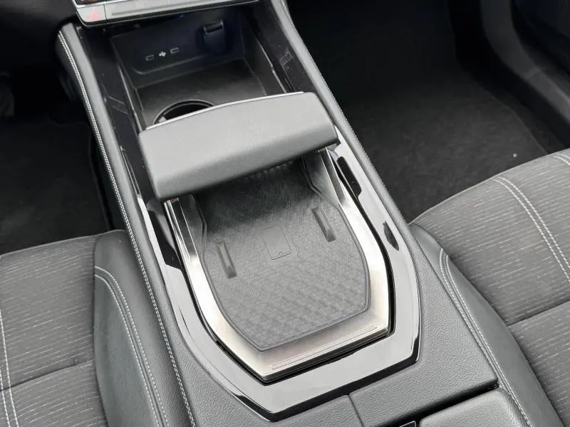 Vue plongeante sur la console centrale noire du Renault Austral 2024 avec accoudoir et espace de rangement intégré.