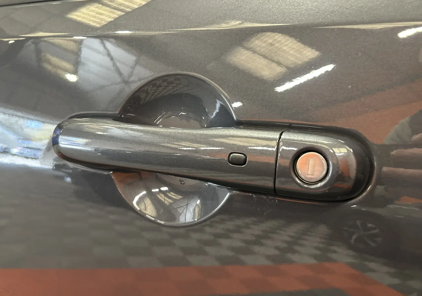Gros plan sur la poignée de porte côté gauche gris graphite d’une Jeep Renegade 2023 avec serrure intégrée.