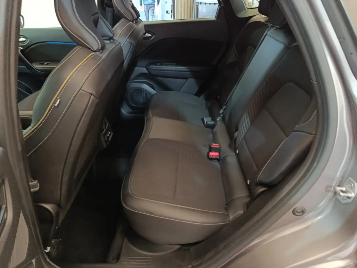 Vue intérieure côté droit sur la banquette arrière noire du Renault SYMBIOZ 2025, avec surpiqûres contrastantes et ceinture rouge.