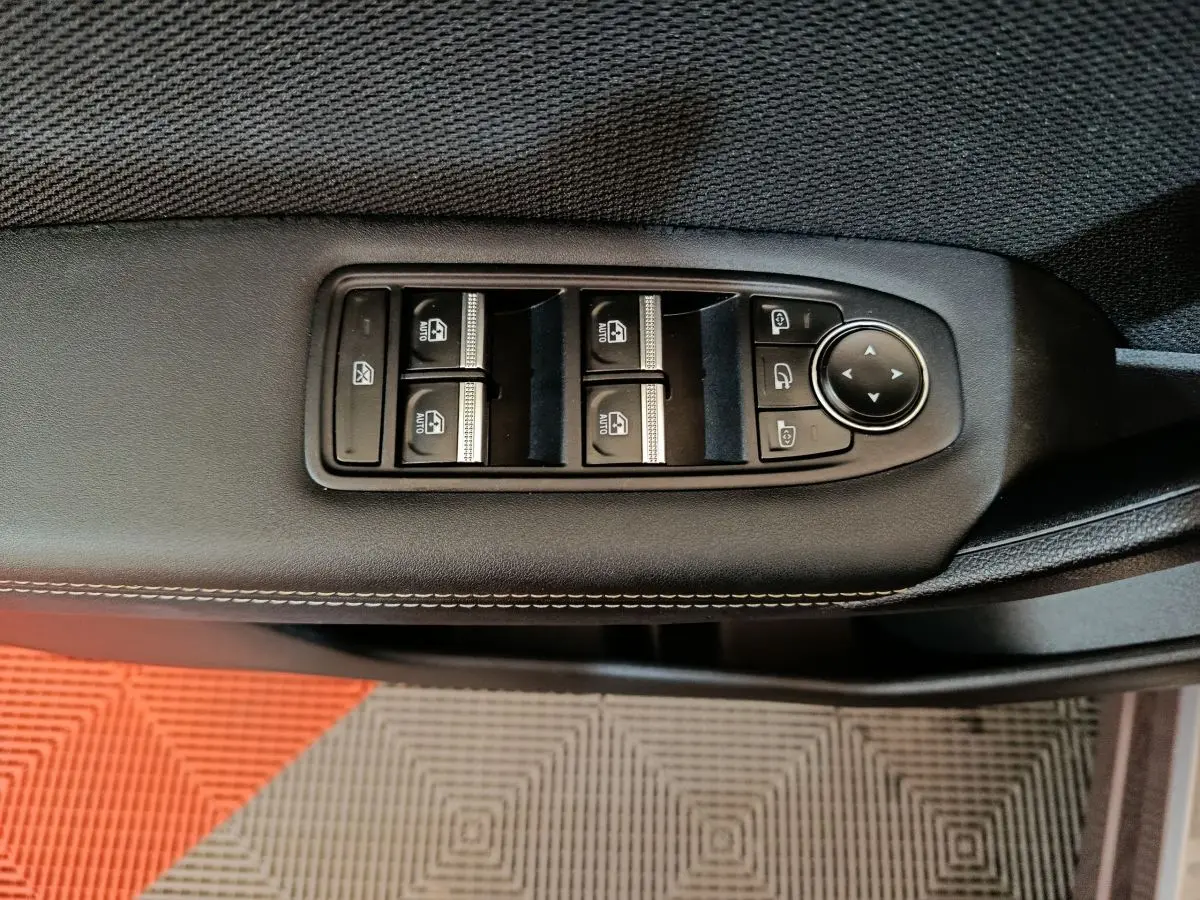 Détail des commandes de lève-vitres et rétroviseurs sur la portière intérieure noire d’une Renault SYMBIOZ 2025.