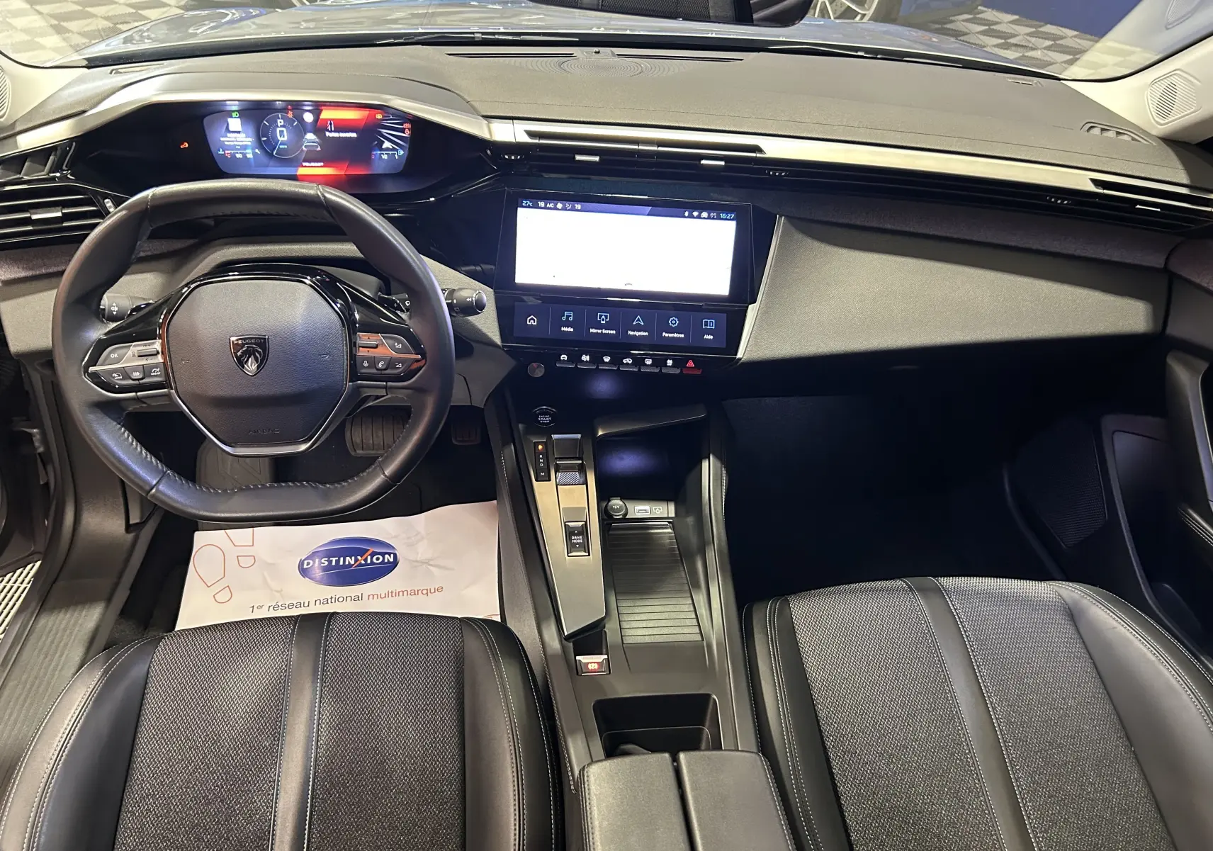 Vue intérieure avant de la Peugeot 308 2022 gris, avec tableau de bord digital et écran tactile central lumineux.