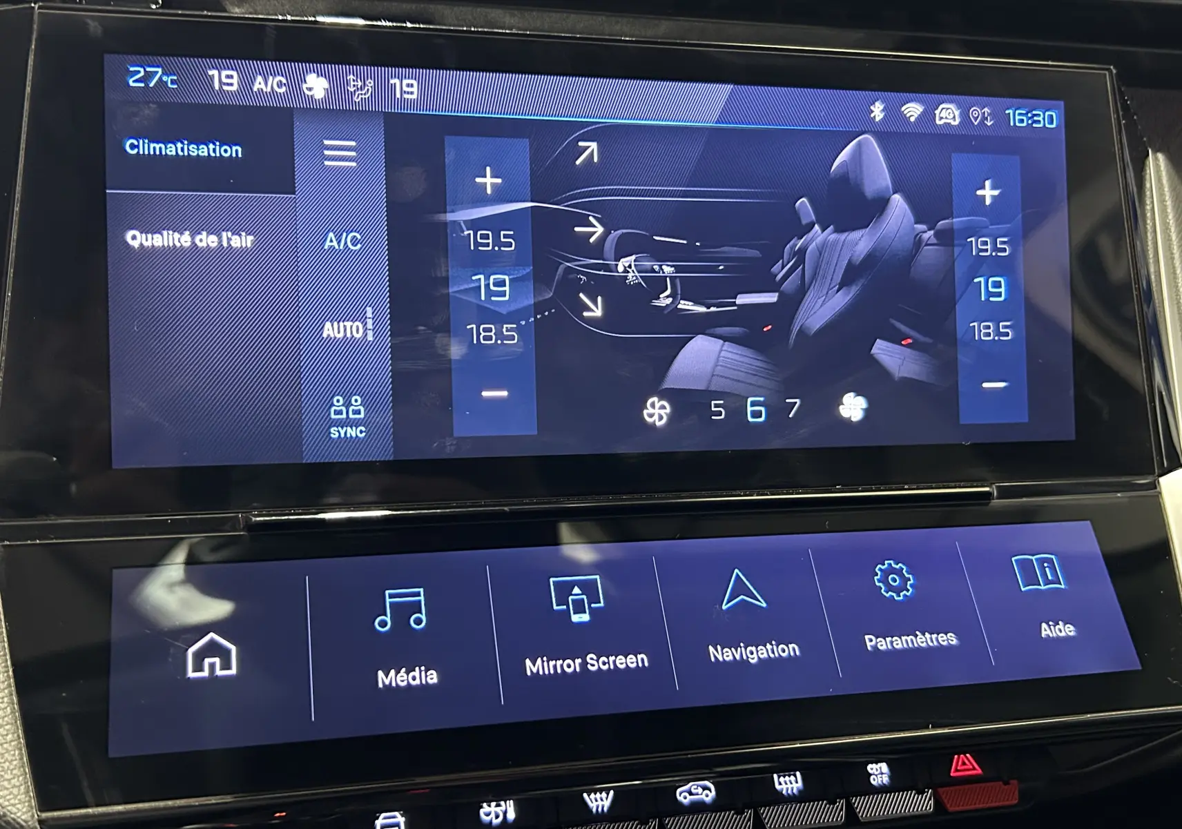 Écran tactile intérieur de Peugeot 308 2022 montrant la climatisation et les options multimédia sur fond noir.