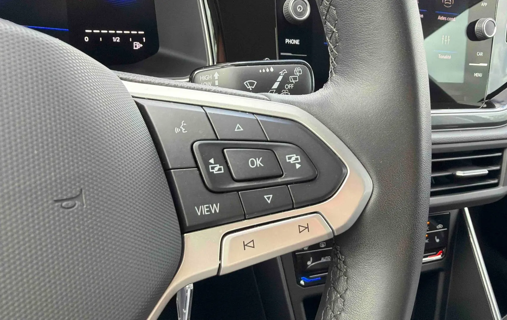 Gros plan sur le volant cuir noir multifonctions côté gauche du Volkswagen Polo 2025 avec commandes intégrées.