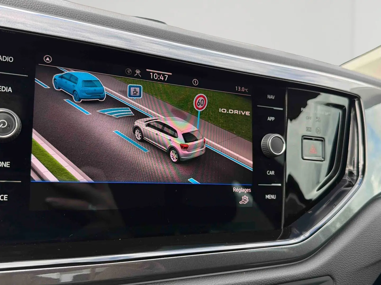 Écran tactile central montrant l'assistance de maintien de voie et la détection des panneaux sur Volkswagen Polo noire.