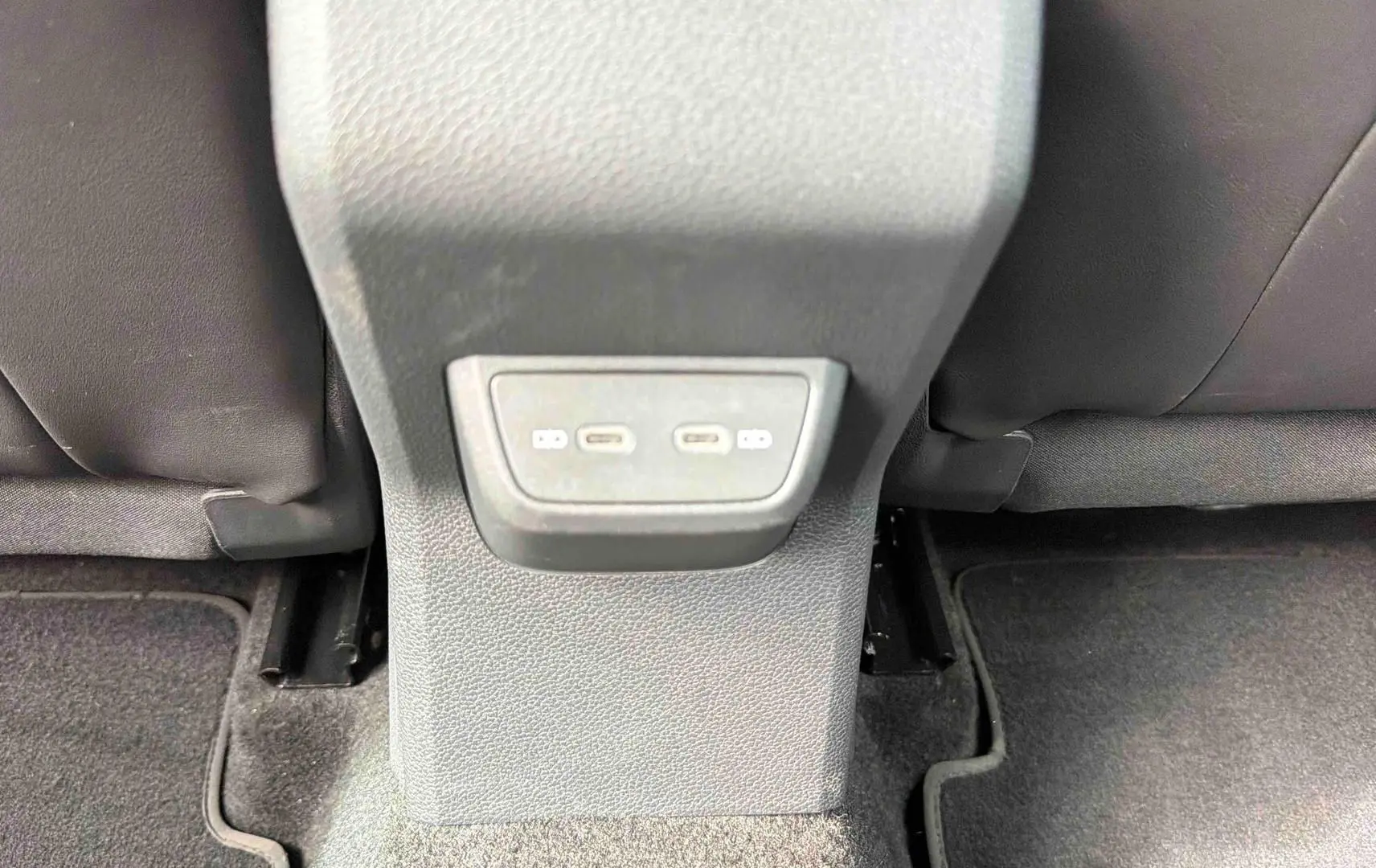 Prise USB-C double vue en gros plan sur la console centrale arrière d’une Volkswagen Polo 2025 noire.