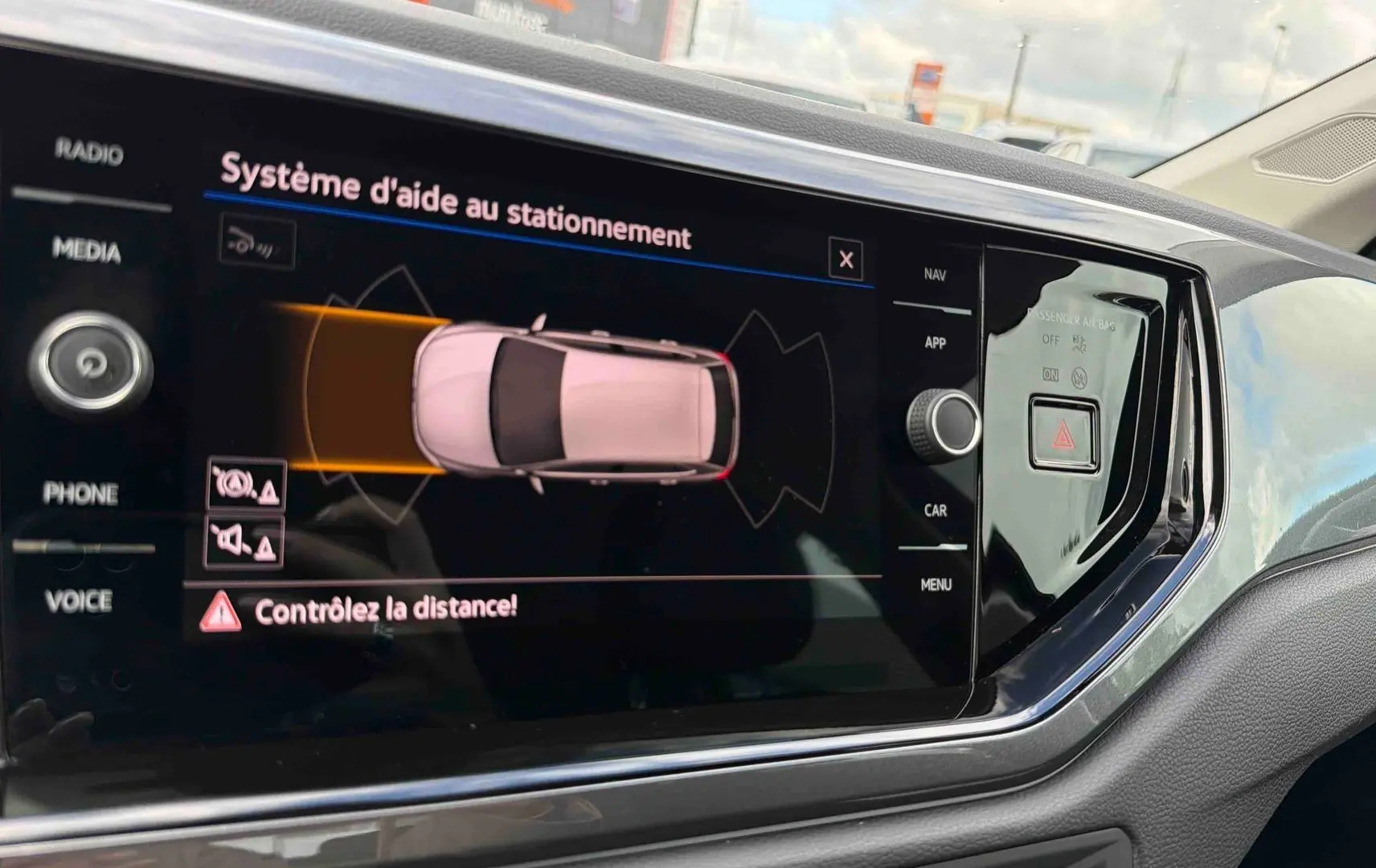 Écran tactile intérieur montrant l’aide au stationnement de la Volkswagen Polo 2025, détails en noir brillant.