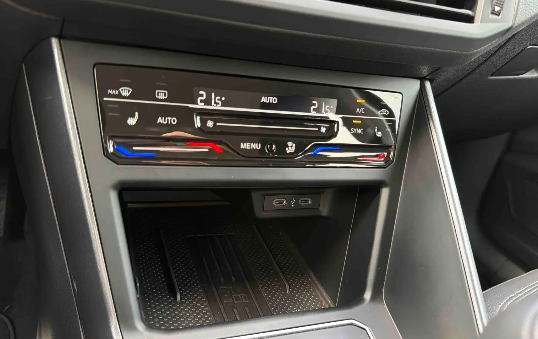 Gros plan sur la console centrale de la Volkswagen Polo noire 2025, montrant la climatisation tactile bi-zone et ports USB-C.