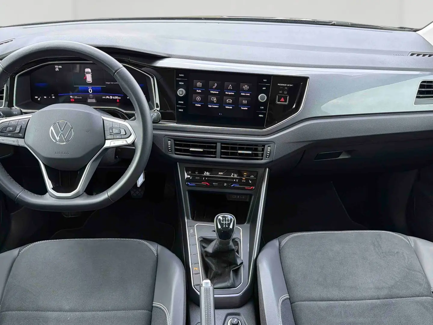 Vue intérieure avant de la Volkswagen Polo noire 2025, montrant le volant cuir multifonctions et la console centrale avec boîte manuelle.