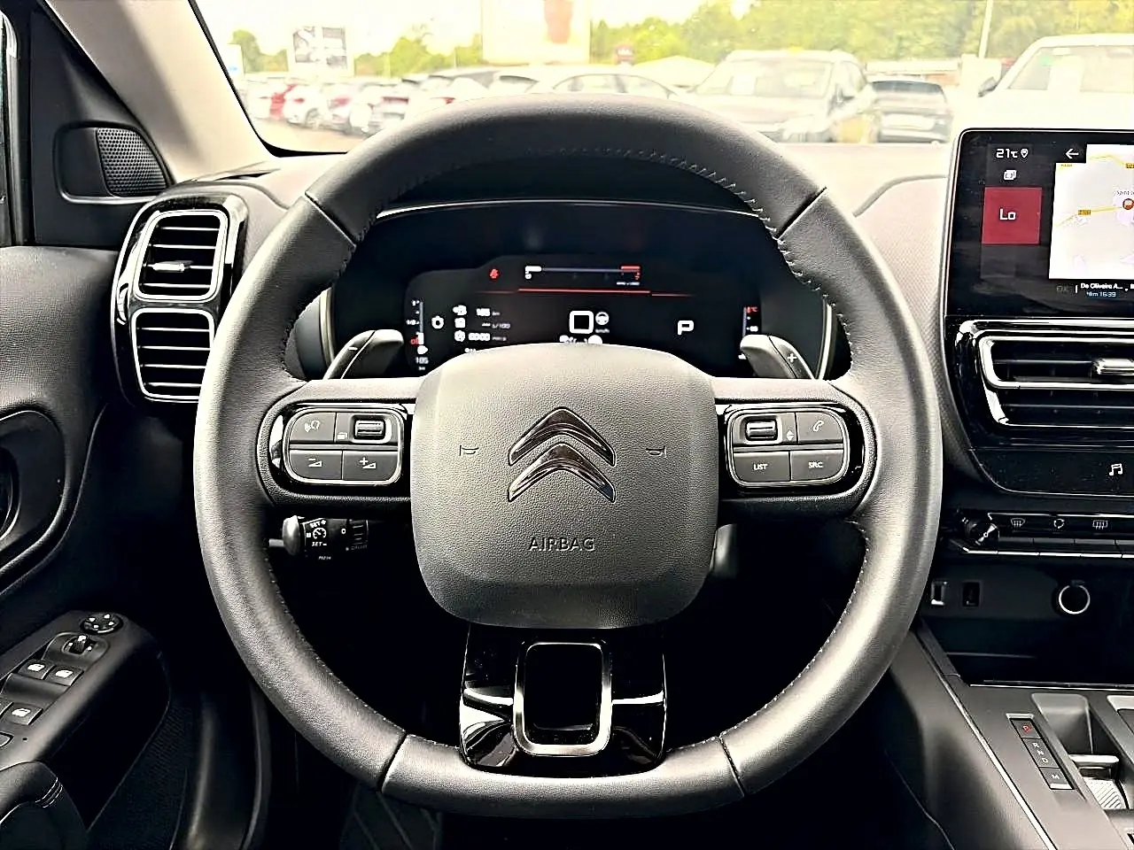 Vue centrée sur le volant cuir noir et le tableau de bord numérique du Citroën C5 Aircross 2025, intérieur moderne.