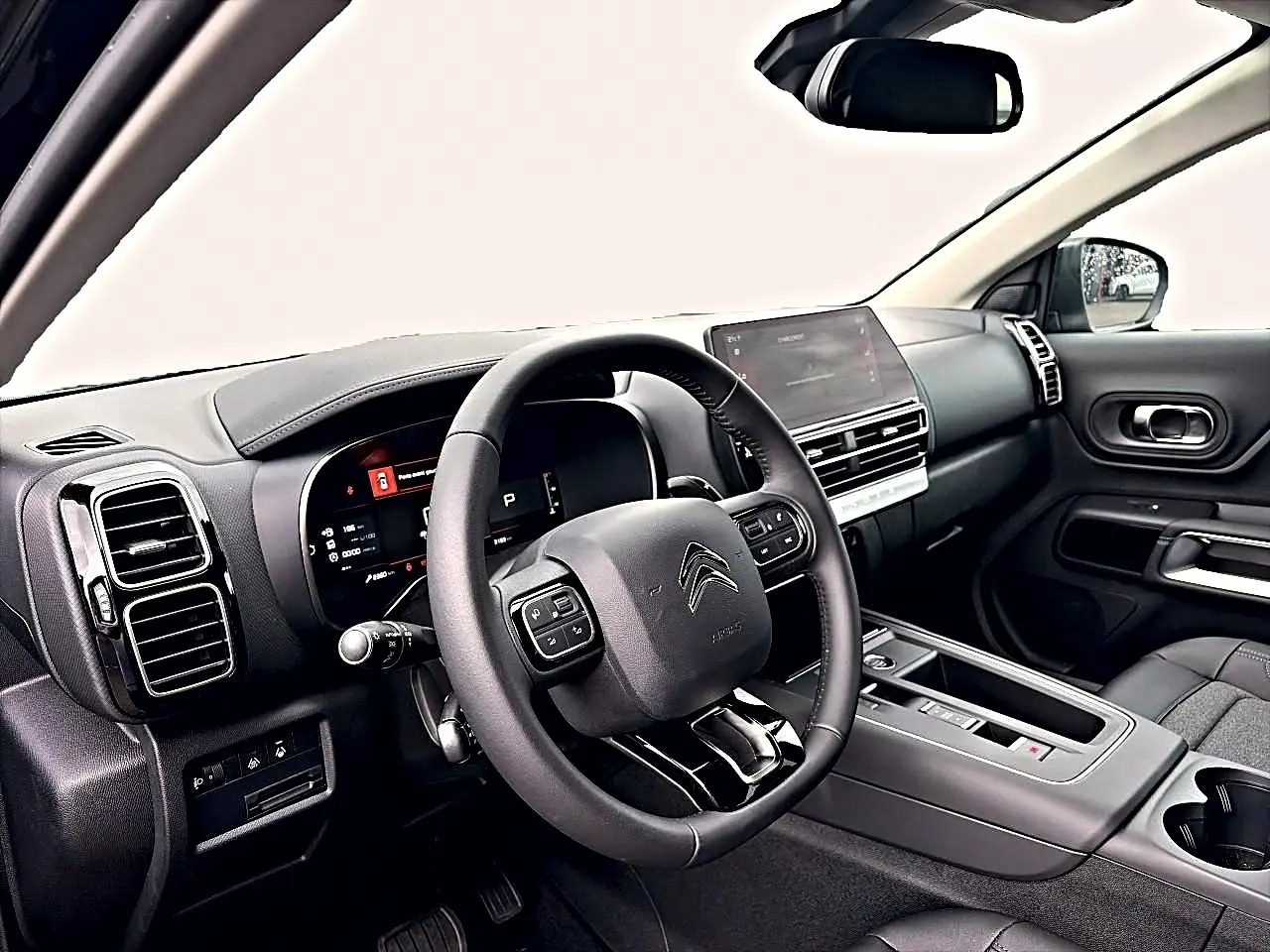 Intérieur noir du Citroën C5 Aircross 2025 vu côté conducteur, avec tableau de bord digital et écran tactile central.