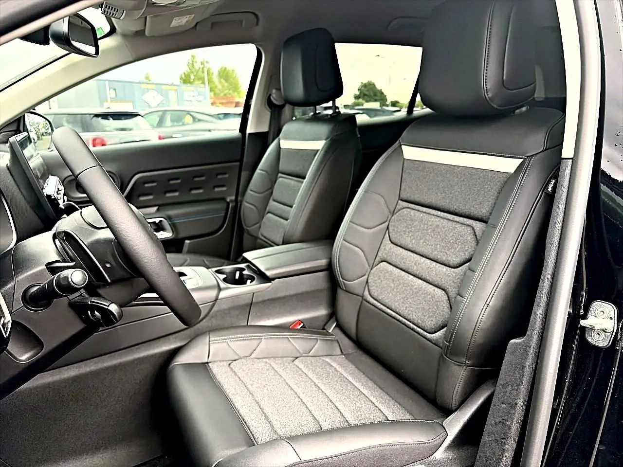 Vue intérieure côté conducteur du Citroën C5 Aircross noir, mettant en valeur les sièges en cuir et tissu gris.