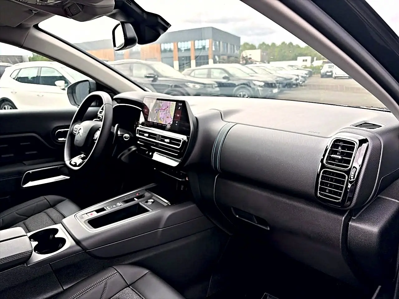 Intérieur noir du Citroën C5 Aircross 2025 vu côté passager, avec écran tactile et volant multifonction.