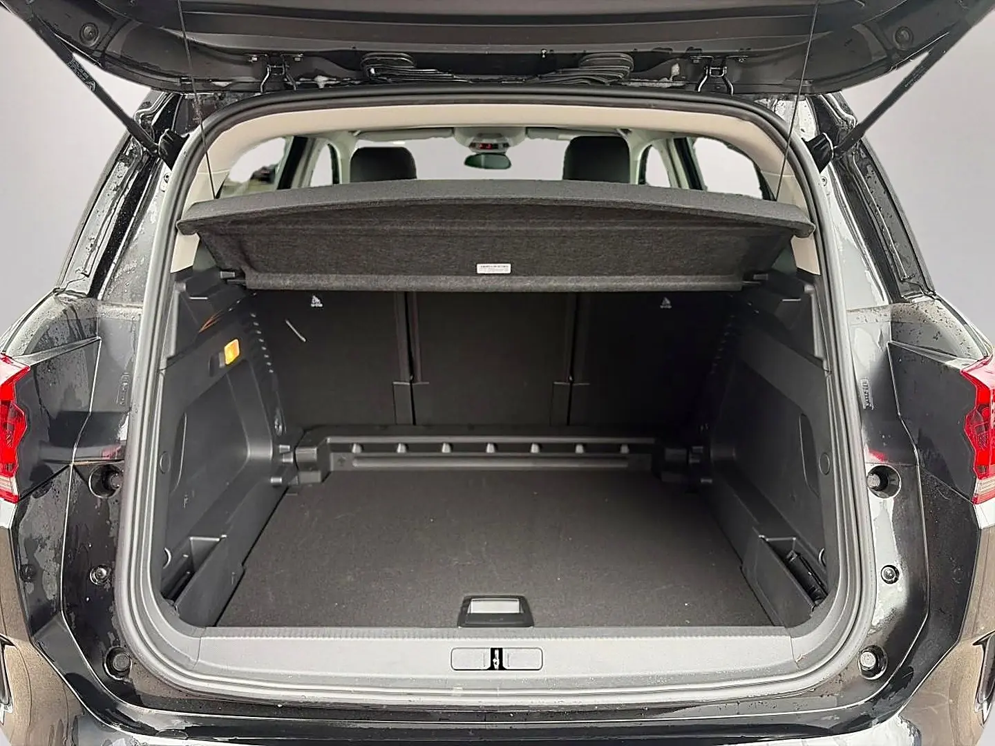 Coffre ouvert en vue arrière d’un Citroën C5 Aircross noir 2025, montrant l’espace de chargement et la tablette cache-bagages.