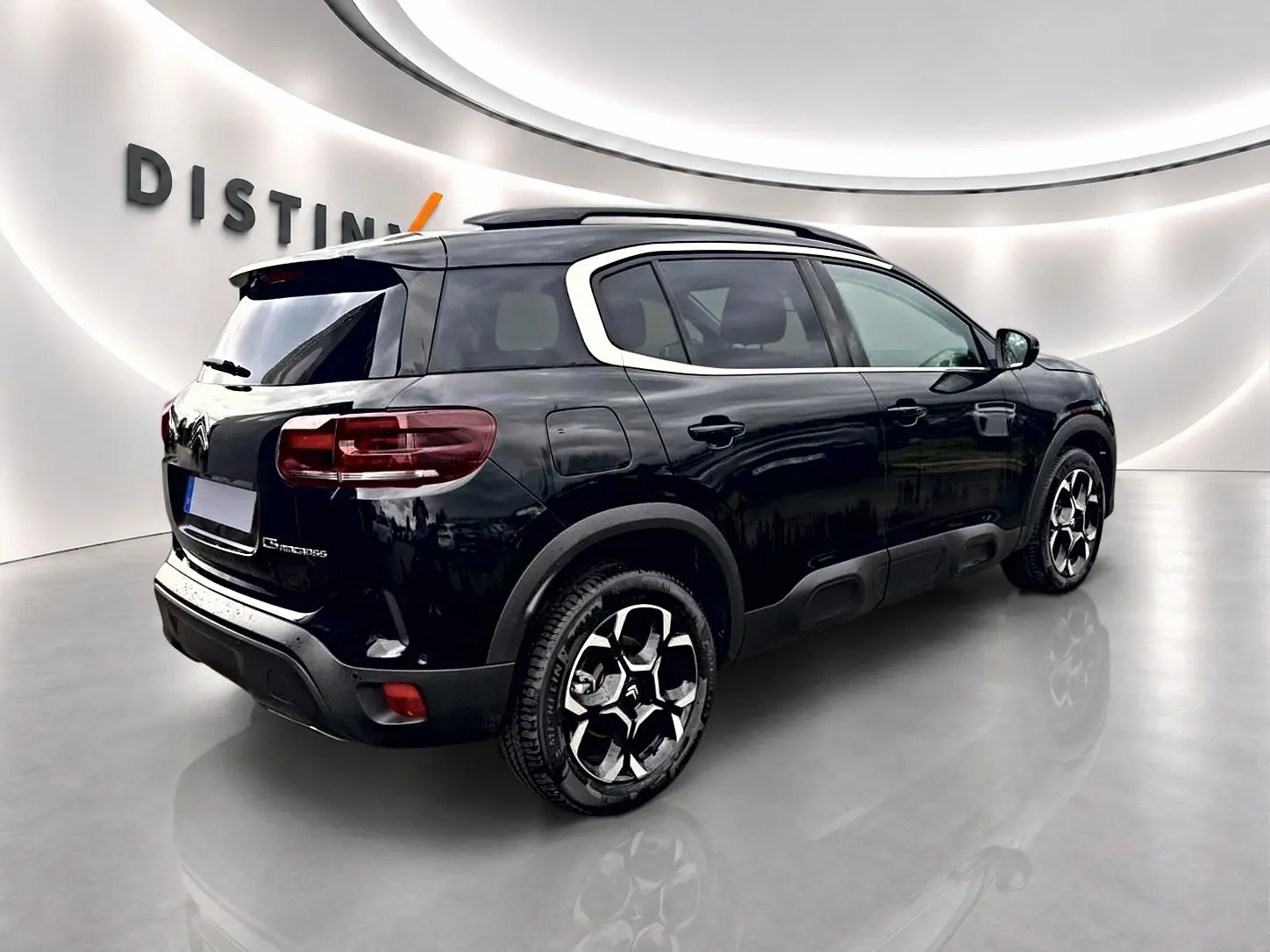 Vue 3/4 arrière droite du Citroën C5 Aircross noir avec barres de toit et jantes alu distinctives.