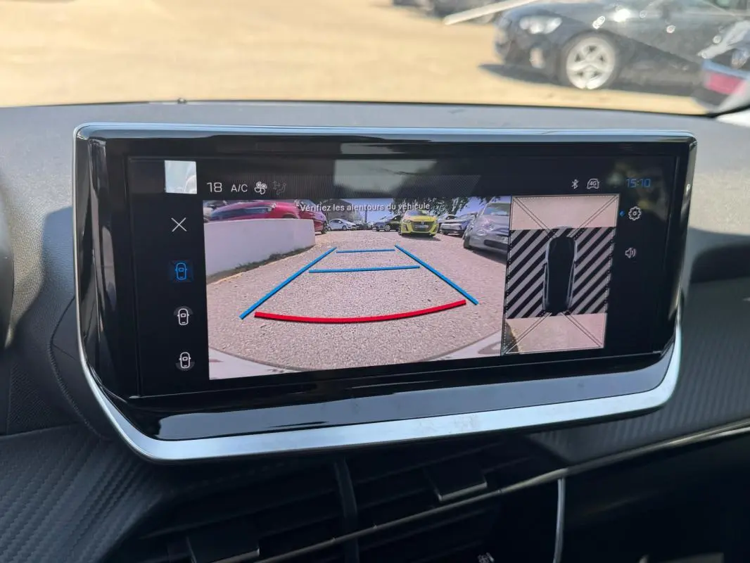 Écran tactile intérieur de la Peugeot 208 gris, affichant la caméra de recul avec lignes de guidage et vue 360° du véhicule.